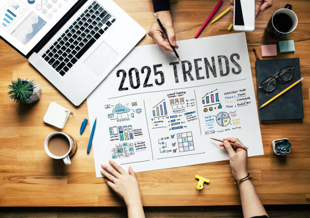 Team analyzing 2025 digital marketing trends with charts and strategy notes on a wooden desk